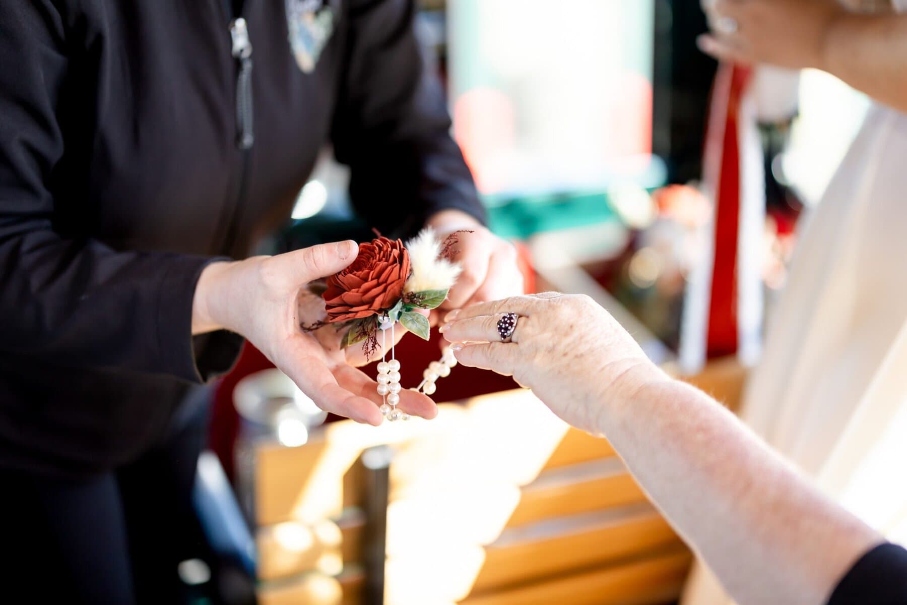 Wedding at the Newport Naval Station Officers' Club 22 Two people exchange a red flower corsage with a pearl bracelet at the Officers' Club, Newport Naval Station.