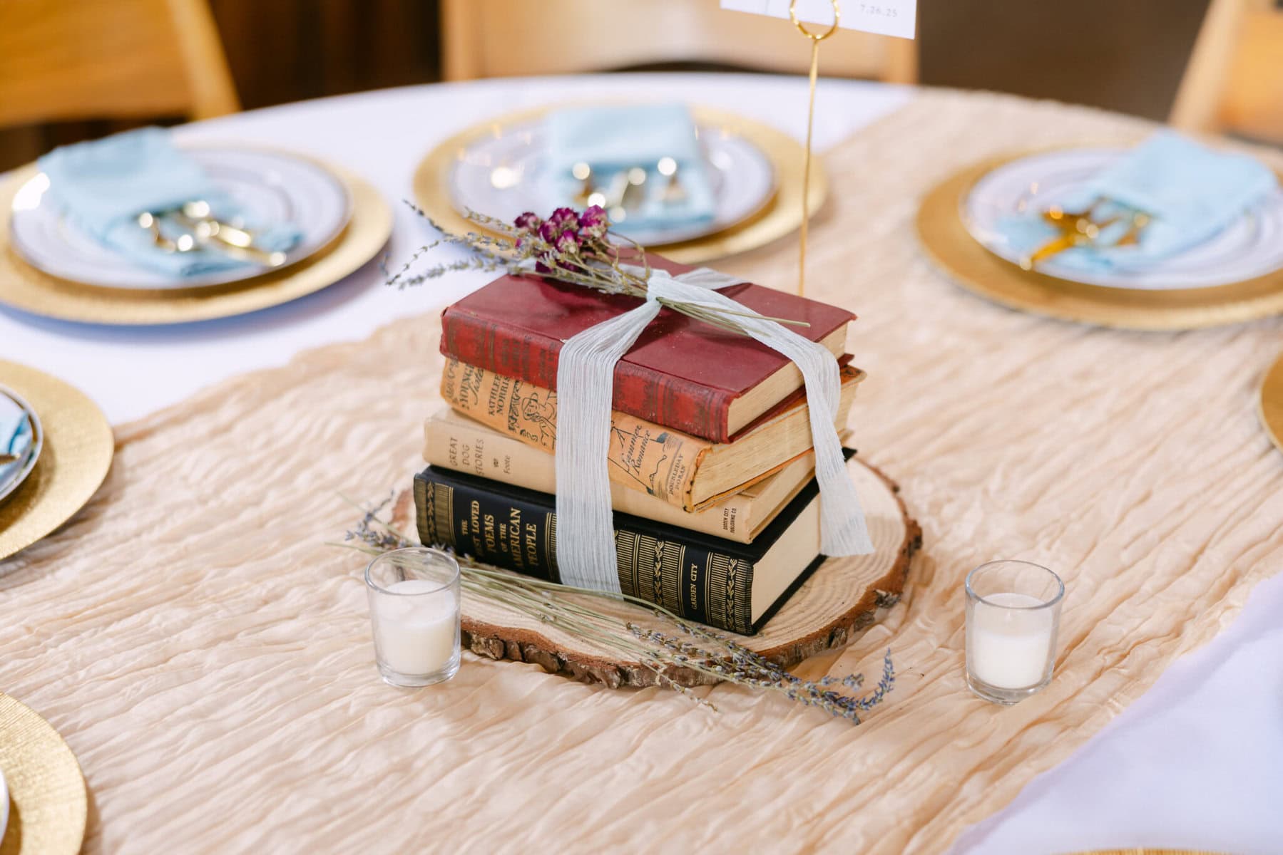 Wedding At the Holliston Historical Society 31 A stack of vintage books tied with ribbon sits on a wooden slab, adding charm to a wedding at Holliston Historical Society.