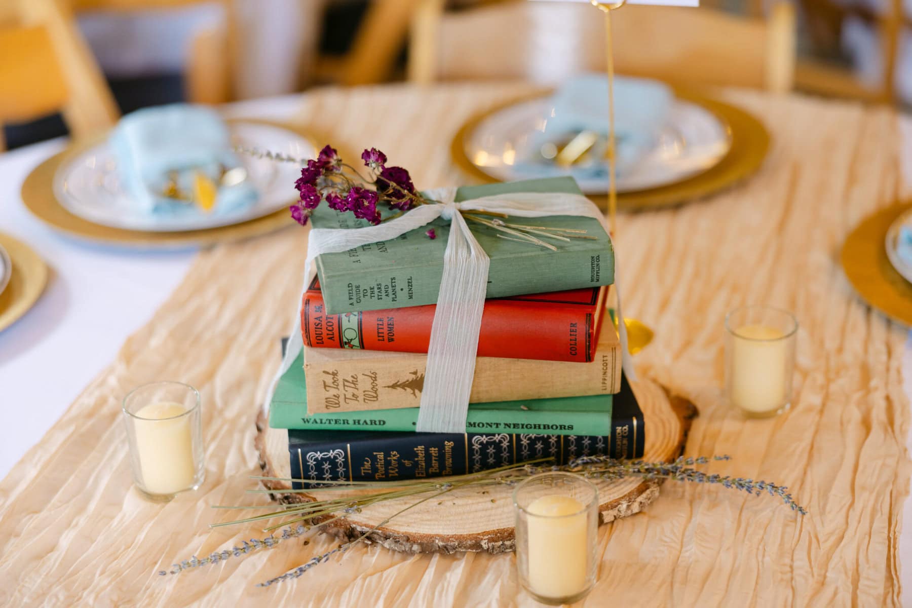 Wedding At the Holliston Historical Society 33 A stack of books with ribbon and flowers creates a charming wedding centerpiece at the Holliston Historical Society event table.