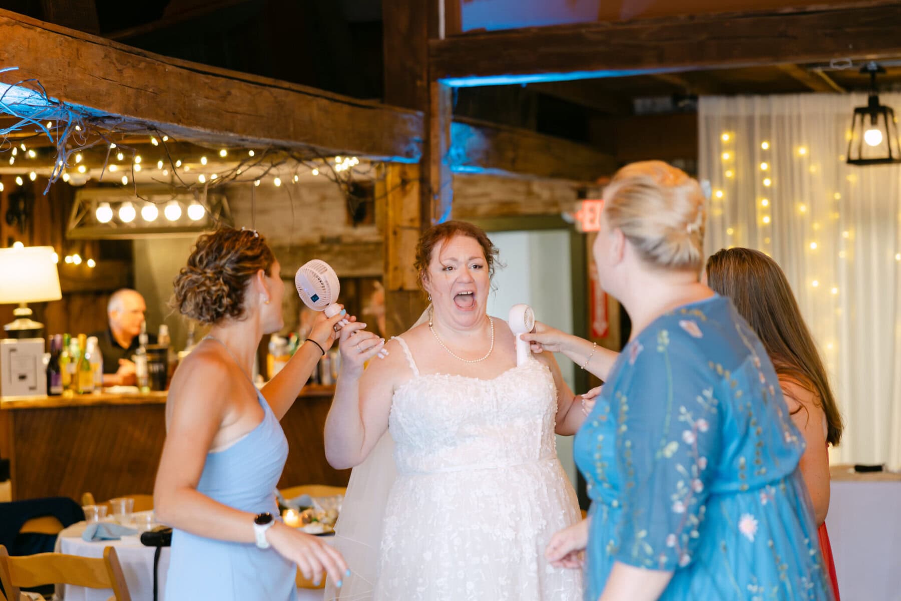 Wedding At the Holliston Historical Society 50 Four women stand indoors at the Holliston Historical Society wedding, three holding toy microphones toward the bride in a white dress.