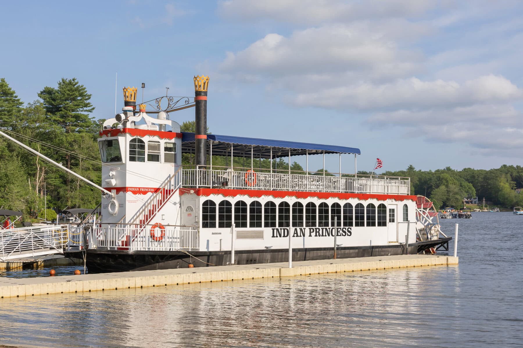 Stunning Wedding at Indian Ranch and Samuel Slater's Restaurant 31 A paddlewheel riverboat named "Indian Princess" docked at Indian Ranch's wooden pier, with trees and clouds in the background.