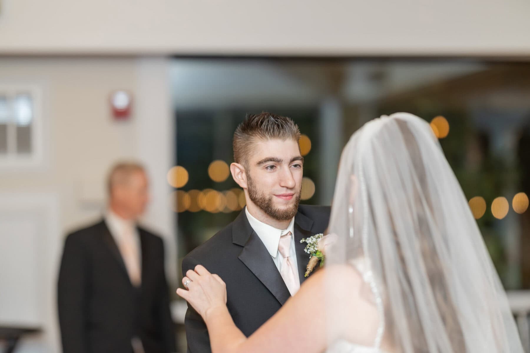 Beautiful Lake Pearl Wedding in Wrentham, MA 33 A bride and groom share a dance indoors at their Lake Pearl Wedding in Wrentham, MA, with the groom facing the camera.