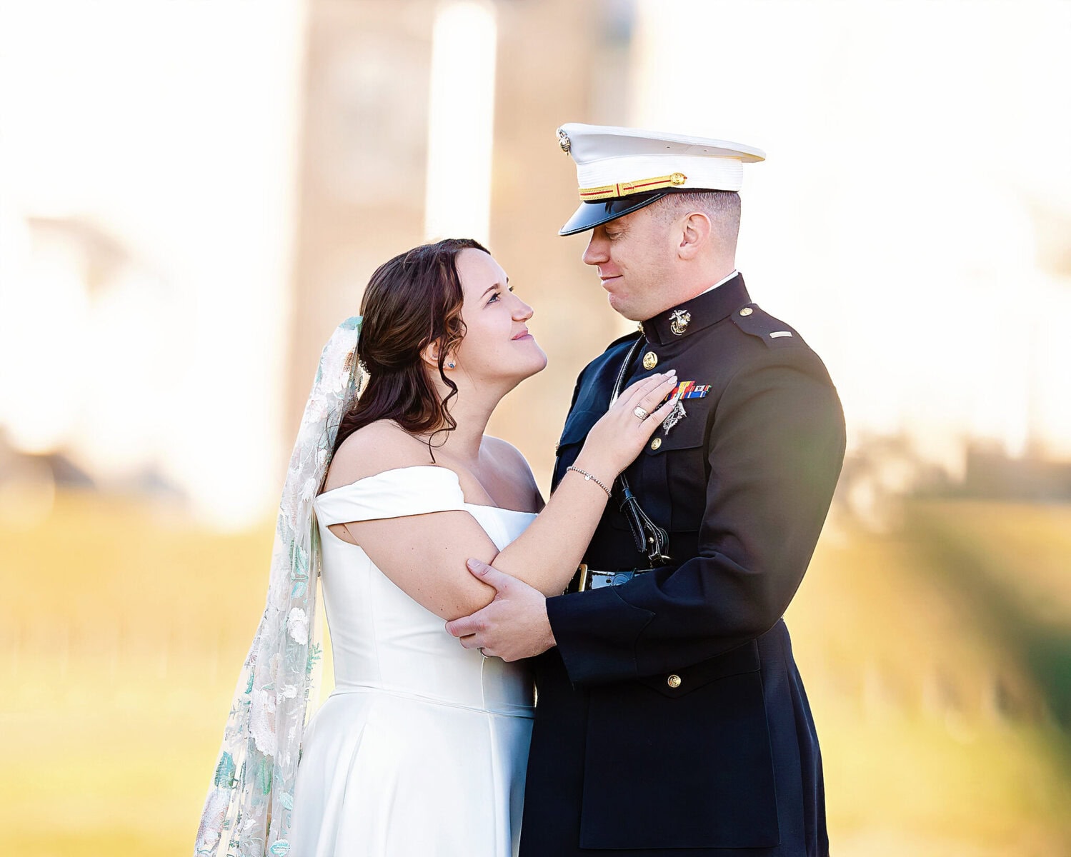 Wedding at the Newport Naval Station Officers' Club 44 A bride in white and a groom in Marine dress uniform share a moment outdoors at their Newport Naval Station wedding.