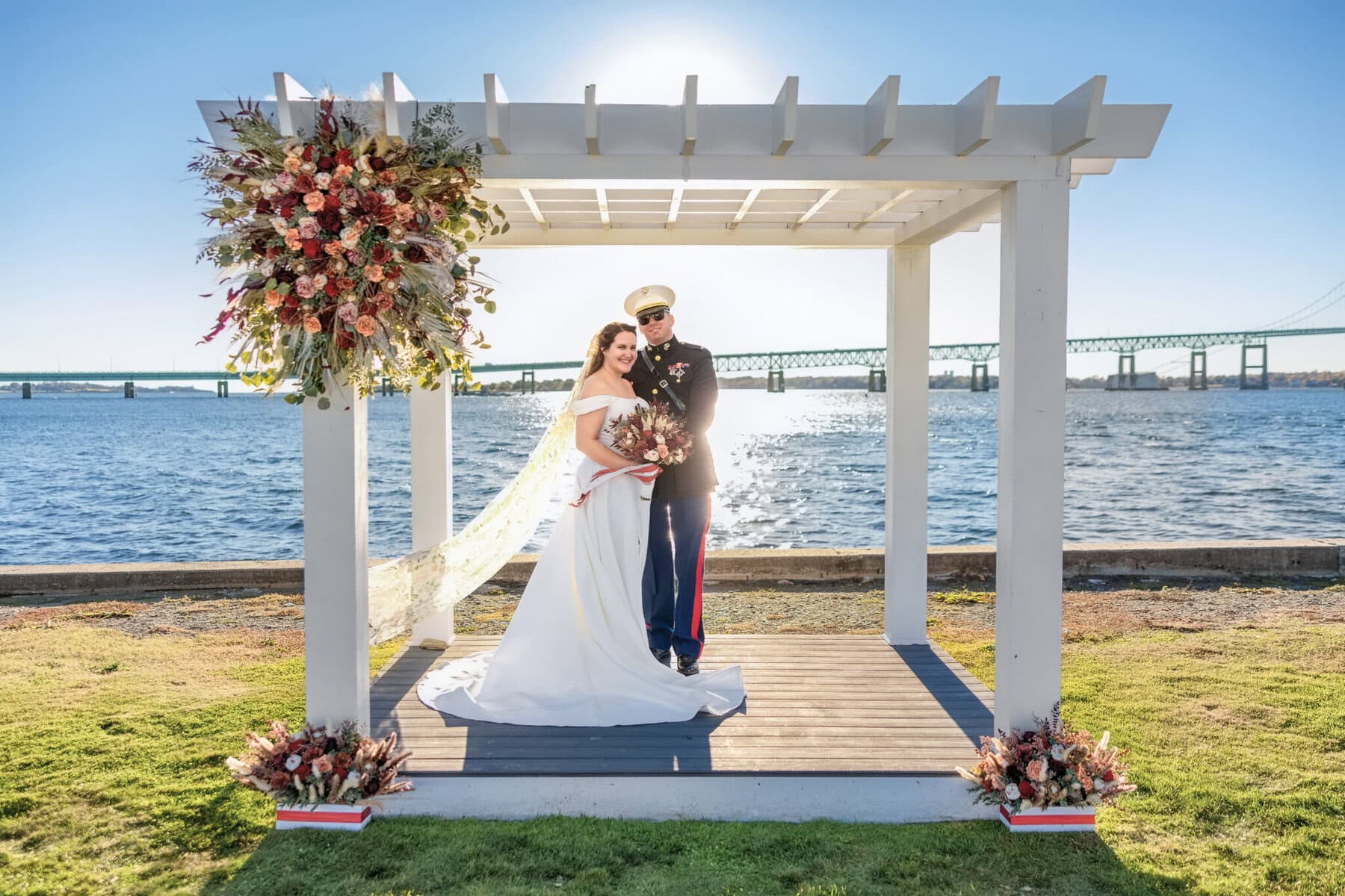 Wedding at the Newport Naval Station Officers' Club 46 A man and woman in wedding attire under a white pergola at the Officers' Club, Newport Naval Station.