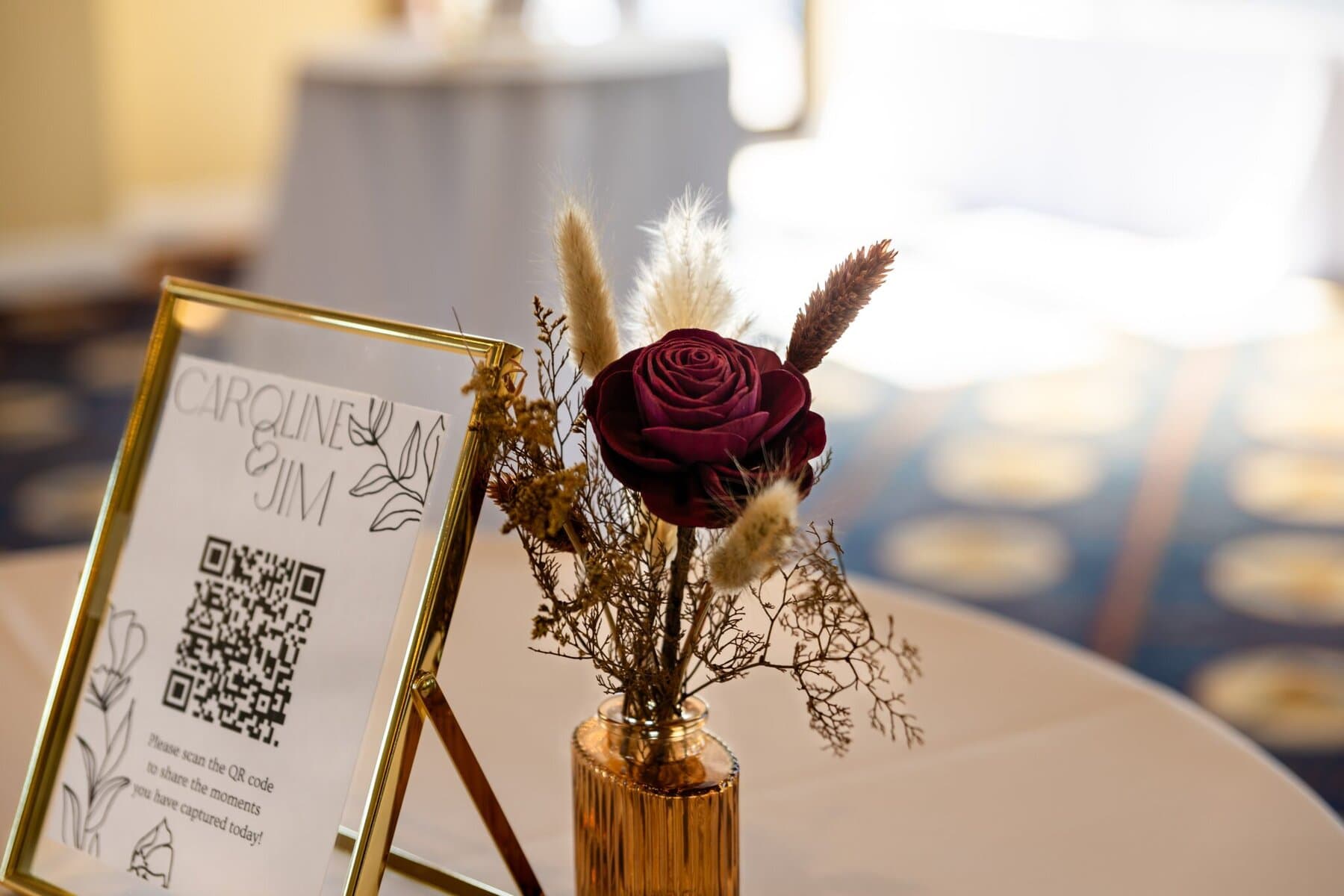 Wedding at the Newport Naval Station Officers' Club 56 A framed QR code and a vase with a red rose adorn a round table at the Officers' Club, perfect for a Newport Naval Station wedding.