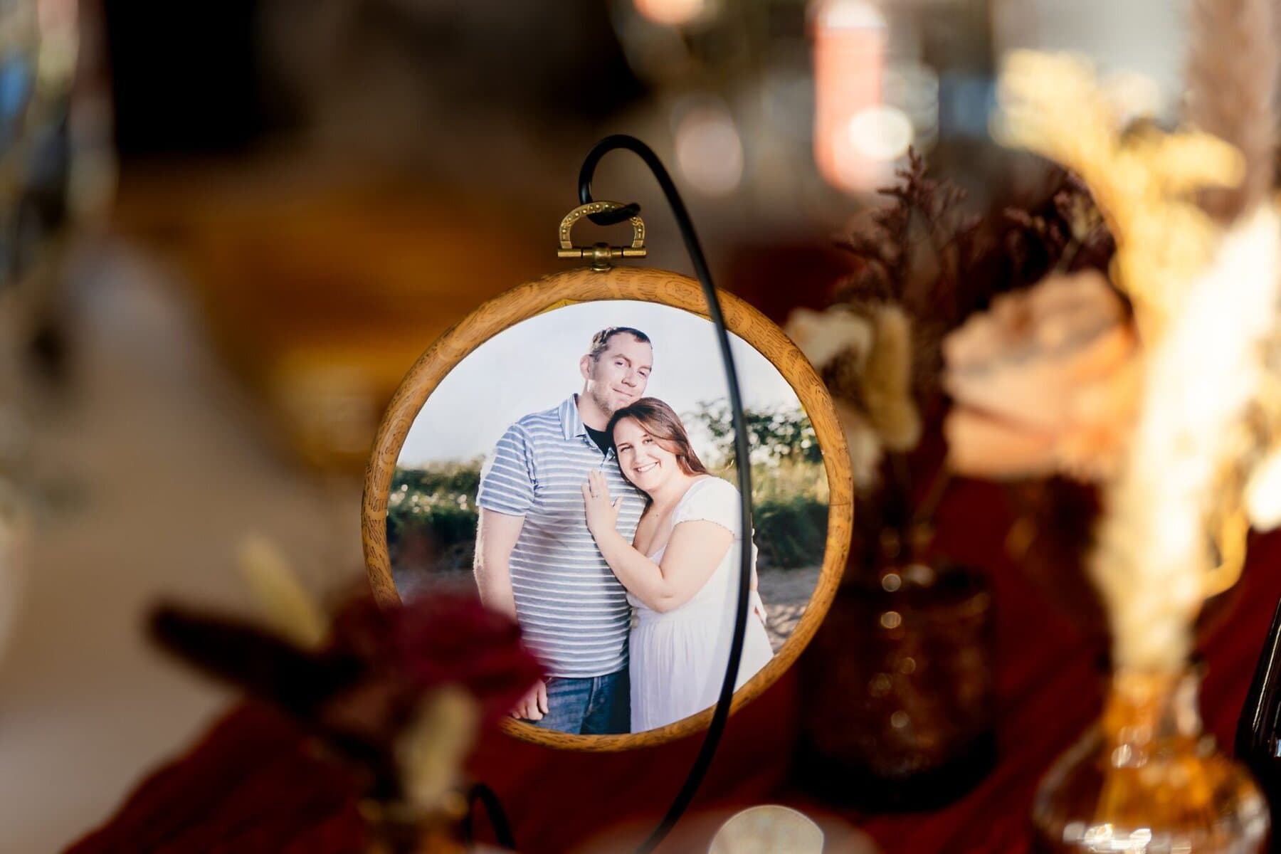 Wedding at the Newport Naval Station Officers' Club 64 A framed photo of a smiling couple at the Officers' Club, Newport Naval Station, is displayed on a table with flowers in the background.