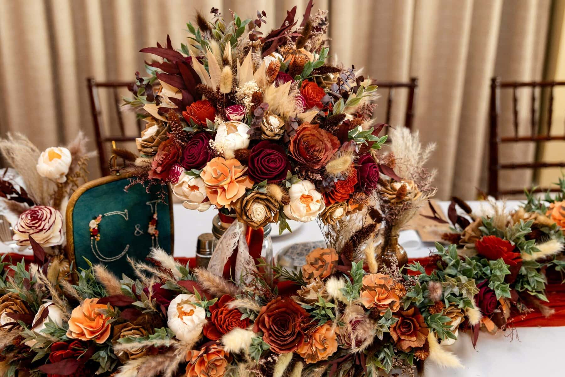 Wedding at the Newport Naval Station Officers' Club 67 A wedding floral centerpiece with red, orange, cream, and beige blooms sits on a white table at Newport Naval Station Officers' Club.