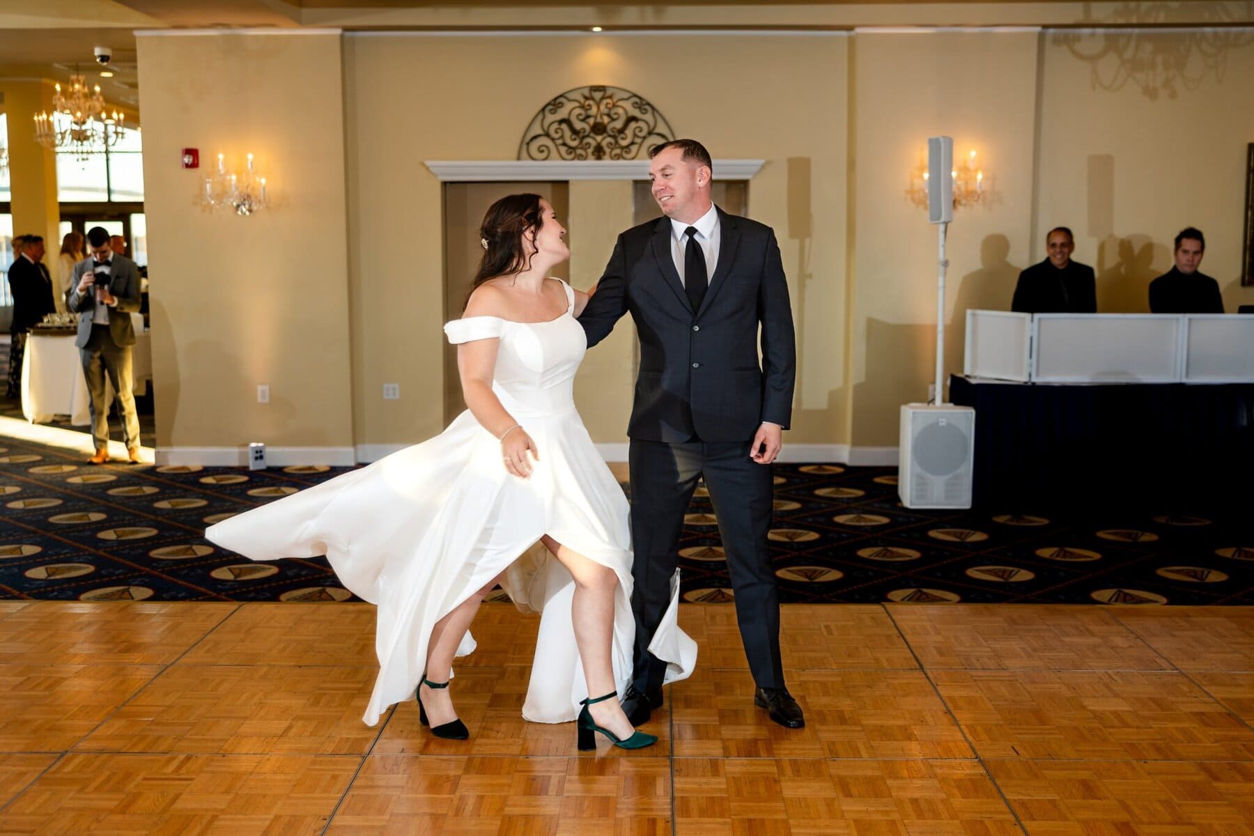 Wedding at the Newport Naval Station Officers' Club 68 A bride in white and groom in a dark suit dance on a wooden floor at their Officers' Club wedding, Newport Naval Station.