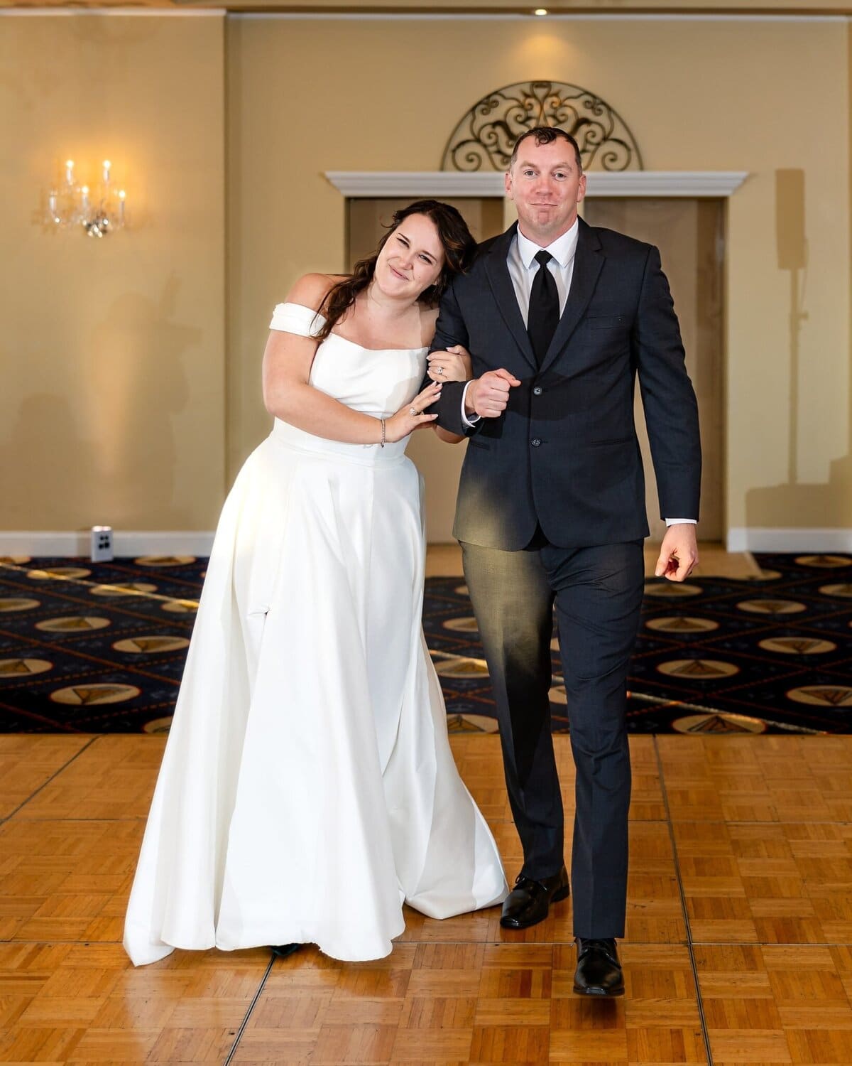 Wedding at the Newport Naval Station Officers' Club 72 A woman in a white wedding dress stands arm-in-arm with a man at their wedding on the dance floor of the Officers' Club at Newport Naval Station.