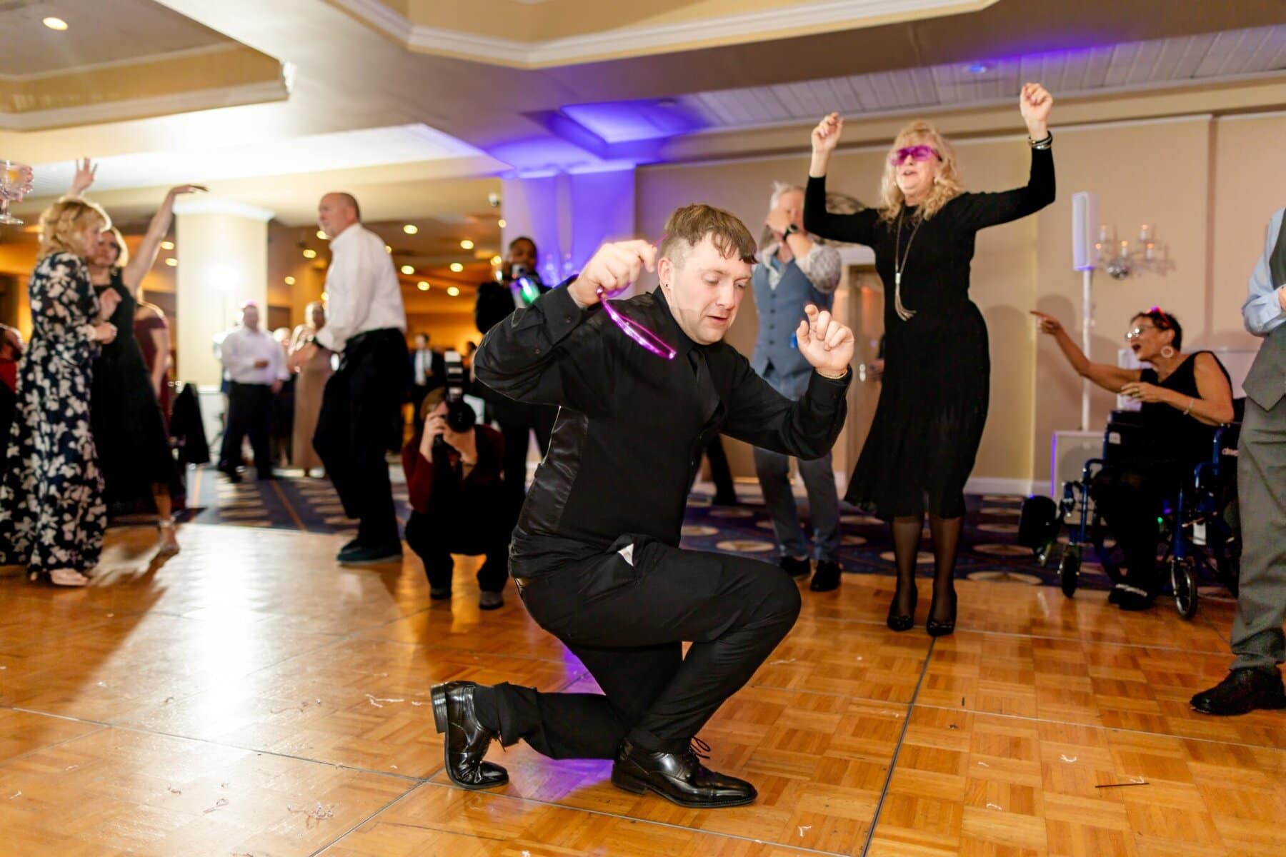 Wedding at the Newport Naval Station Officers' Club 91 A man in black suit dancing with a microphone in his hand at an Officers' Club wedding.