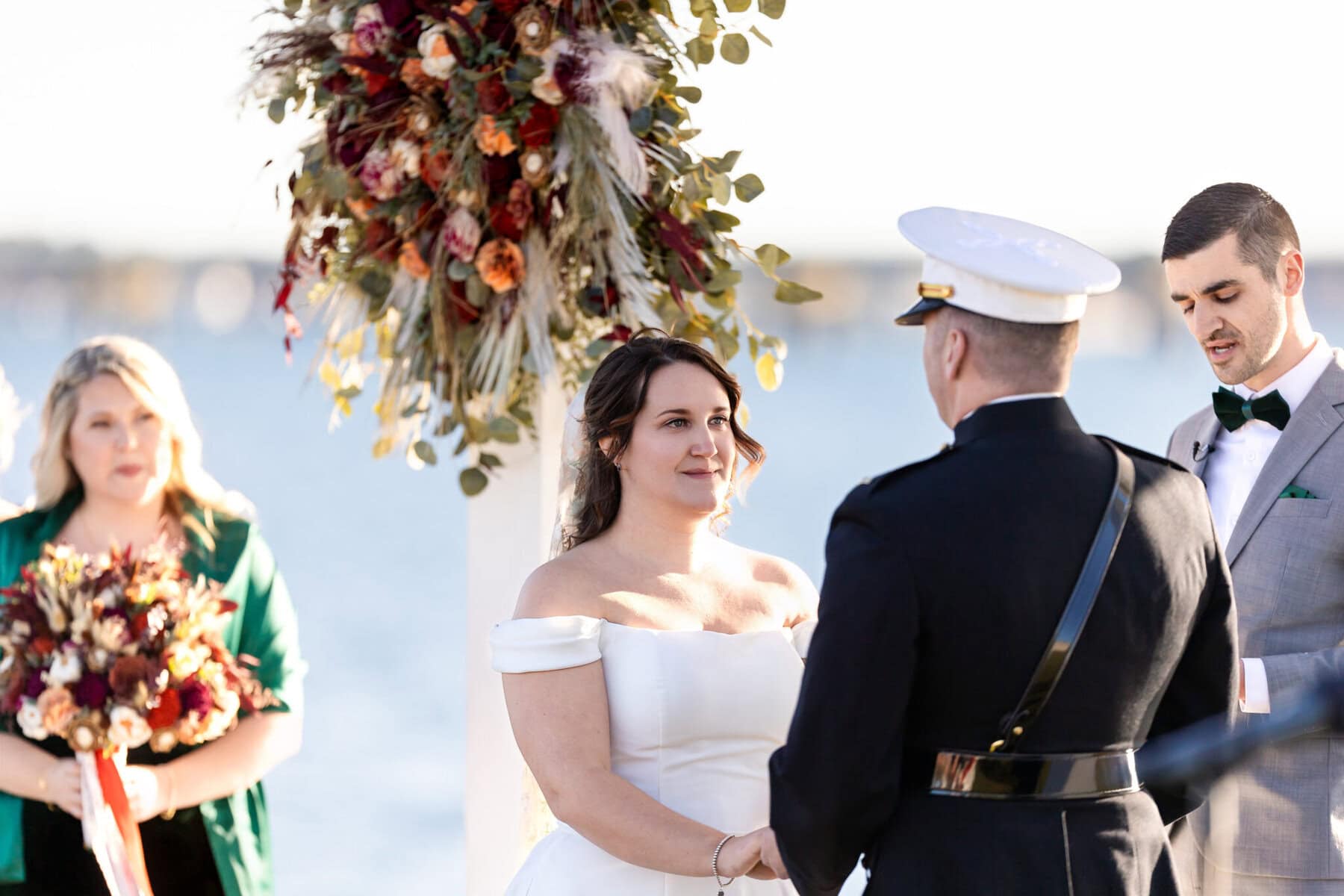 Wedding at the Newport Naval Station Officers' Club 34 A bride and groom exchange vows outdoors at the Officers' Club, Newport Naval Station, with a stunning floral arrangement overhead.