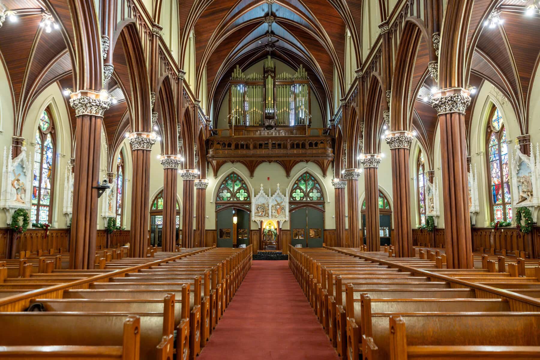 Wedding At the Transfiguration of the Lord Parish 10 Interior view of a large church, perfect for a Wedding, featuring arched ceilings, stained glass, and an organ above the altar for the Transfiguration of the Lord.