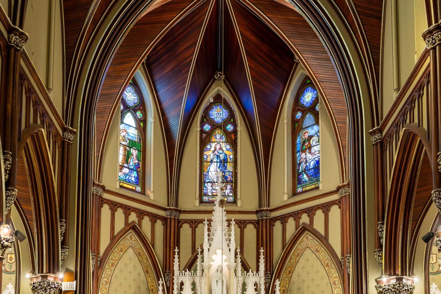 Wedding At the Transfiguration of the Lord Parish 15 Gothic-style church interior with pointed arches and stained glass, perfect for a Wedding ceremony at the ornate white altar in the foreground.