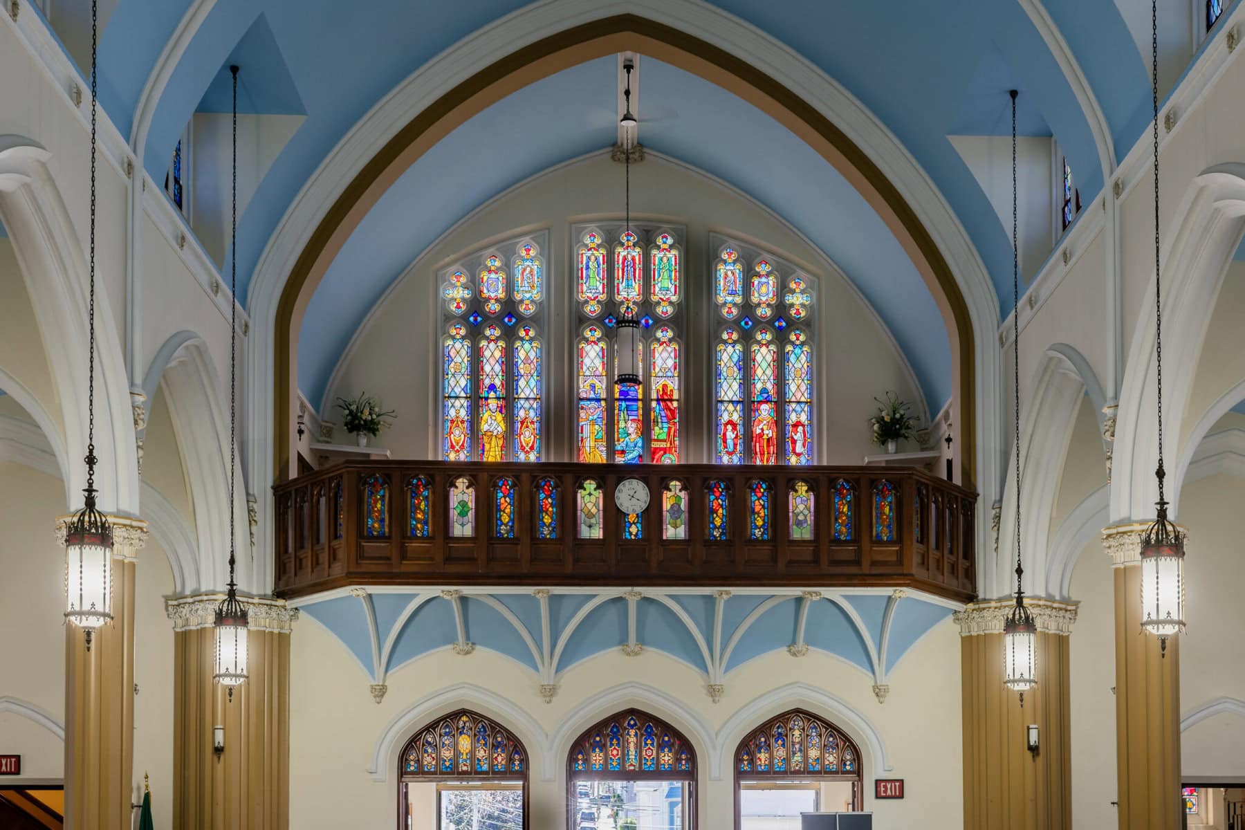 Wedding At Santo Christo Parish in Fall River 10 Interior of Santo Christo Parish in Fall River with arched ceilings, hanging lights, and stained glass—an elegant wedding setting.