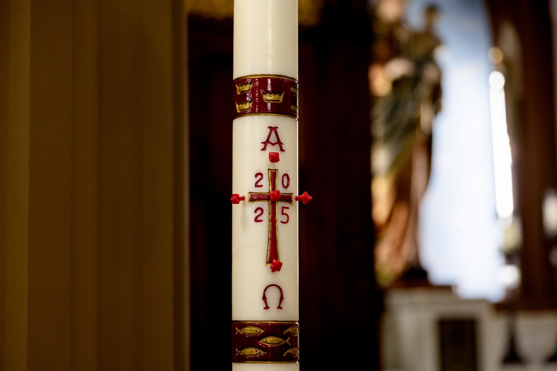 Wedding At Santo Christo Parish in Fall River 13 A white candle with a red cross, 2015, and Alpha & Omega stands in Santo Christo Parish, Fall River, perfect for a wedding setting.