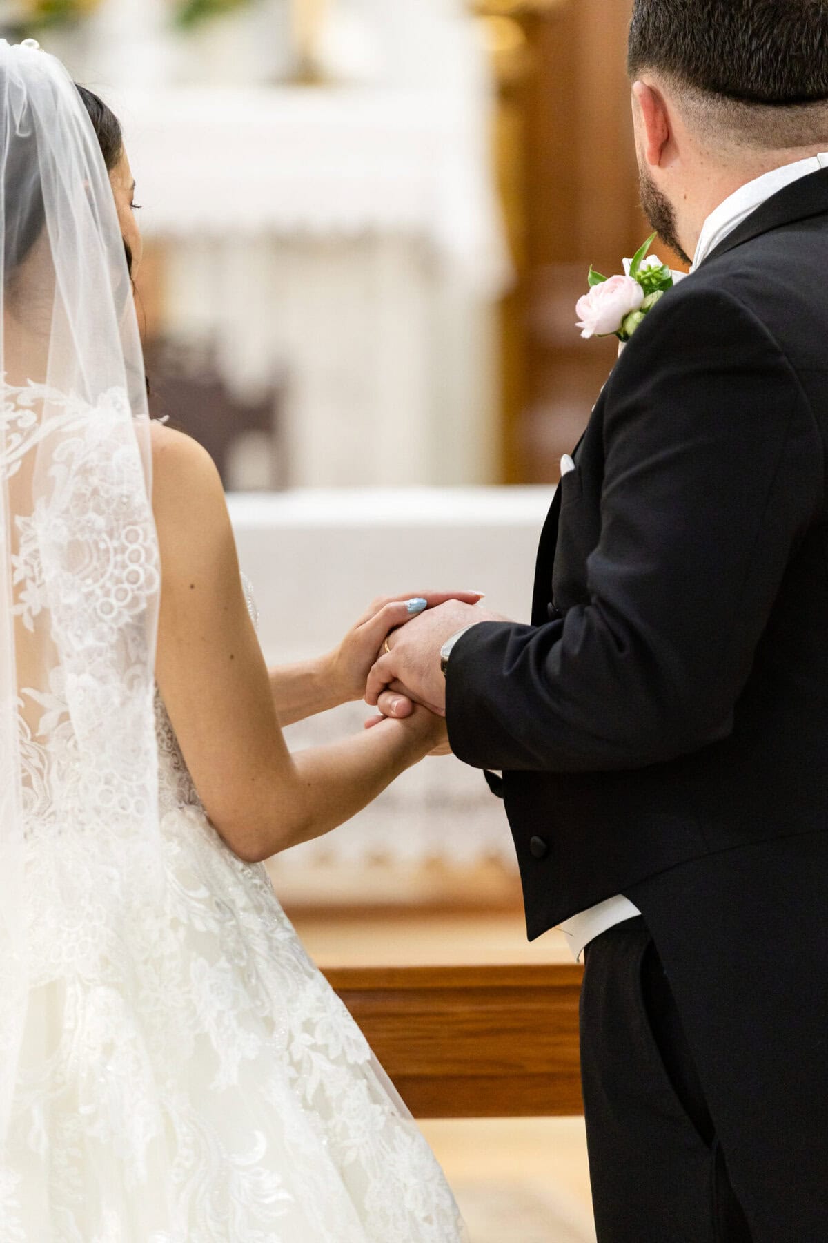 Wedding At Santo Christo Parish in Fall River 43 A bride and groom stand side by side, holding hands during a wedding ceremony at Santo Christo Parish in Fall River.
