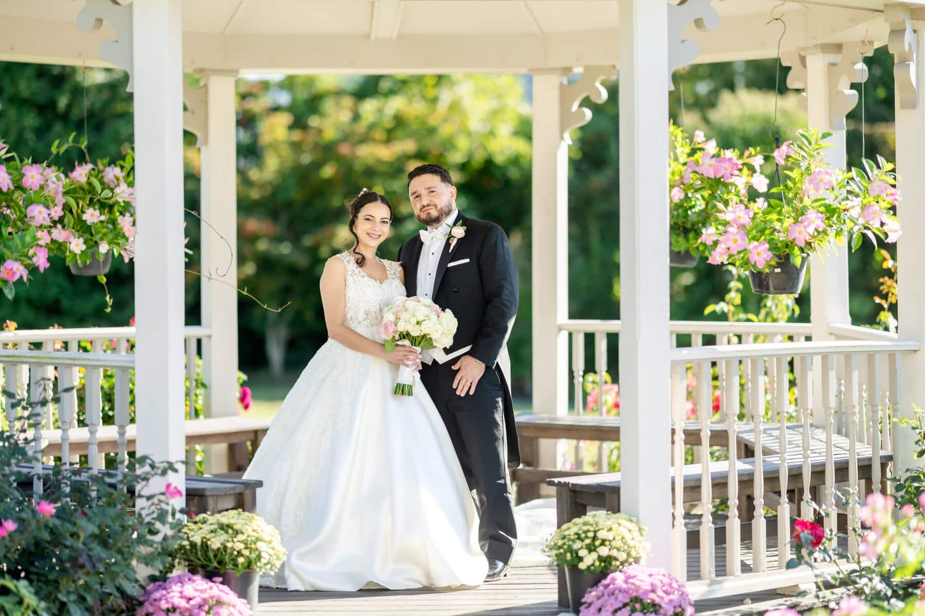 Wedding Photos at Roseland Nursery 6 A bride and groom stand in a gazebo at Roseland Nursery, surrounded by flowers—perfect for stunning wedding photography.