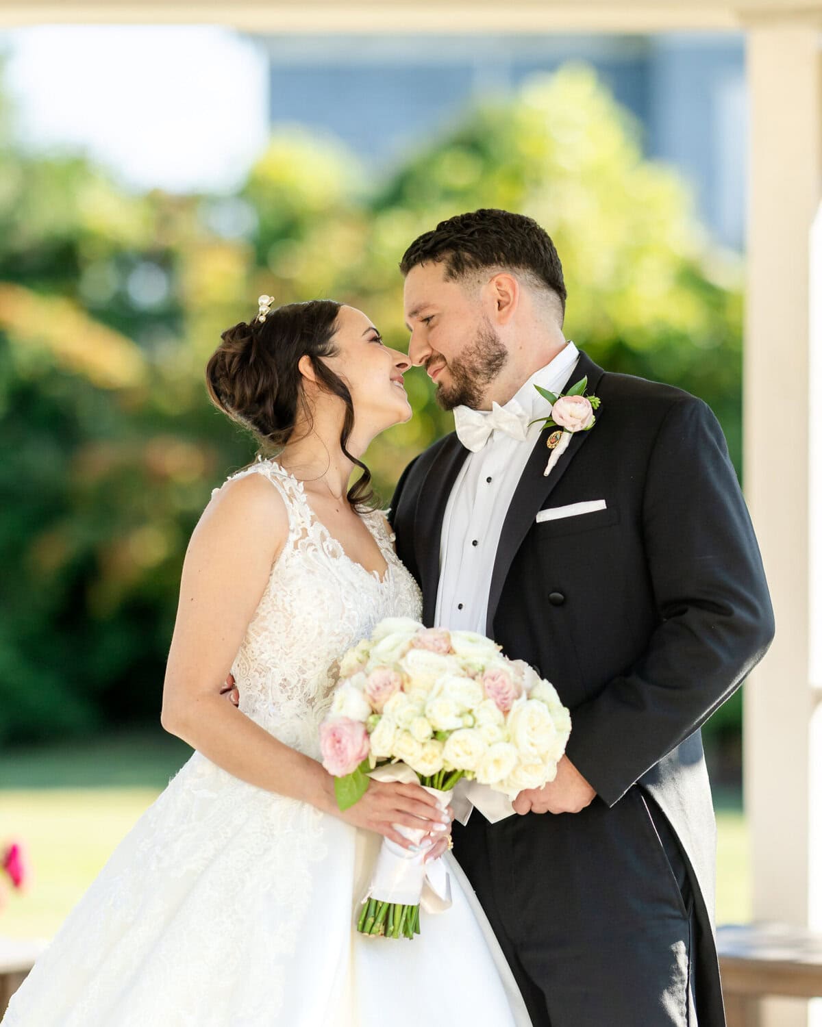 Wedding Photos at Roseland Nursery 15 A bride and groom stand close together outdoors at Roseland Nursery, smiling and holding a bouquet—perfect for timeless wedding photography.