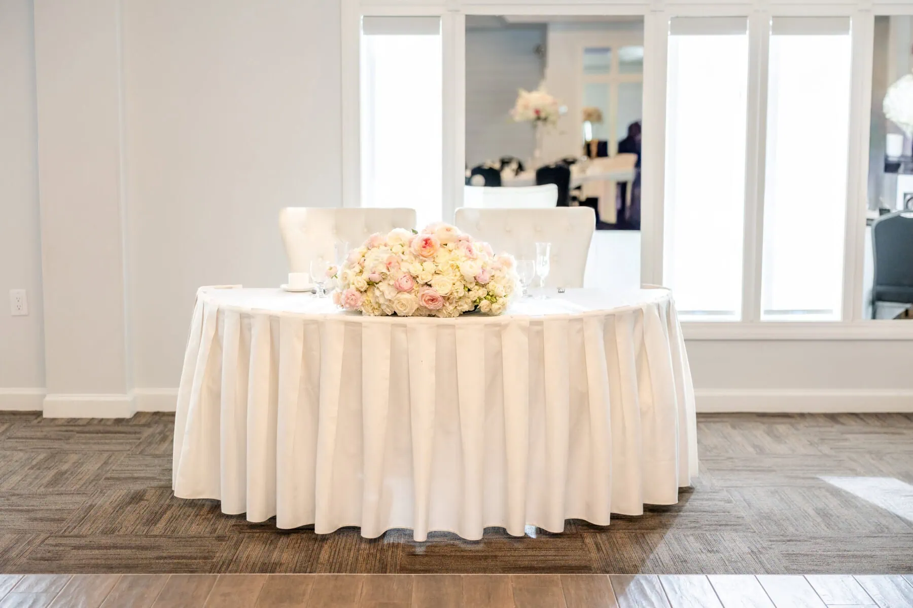 Wedding Reception at The Century House in Acushnet 2 A round table with a white tablecloth and floral centerpiece, set for two at The Century House in Acushnet—perfect for a wedding reception.