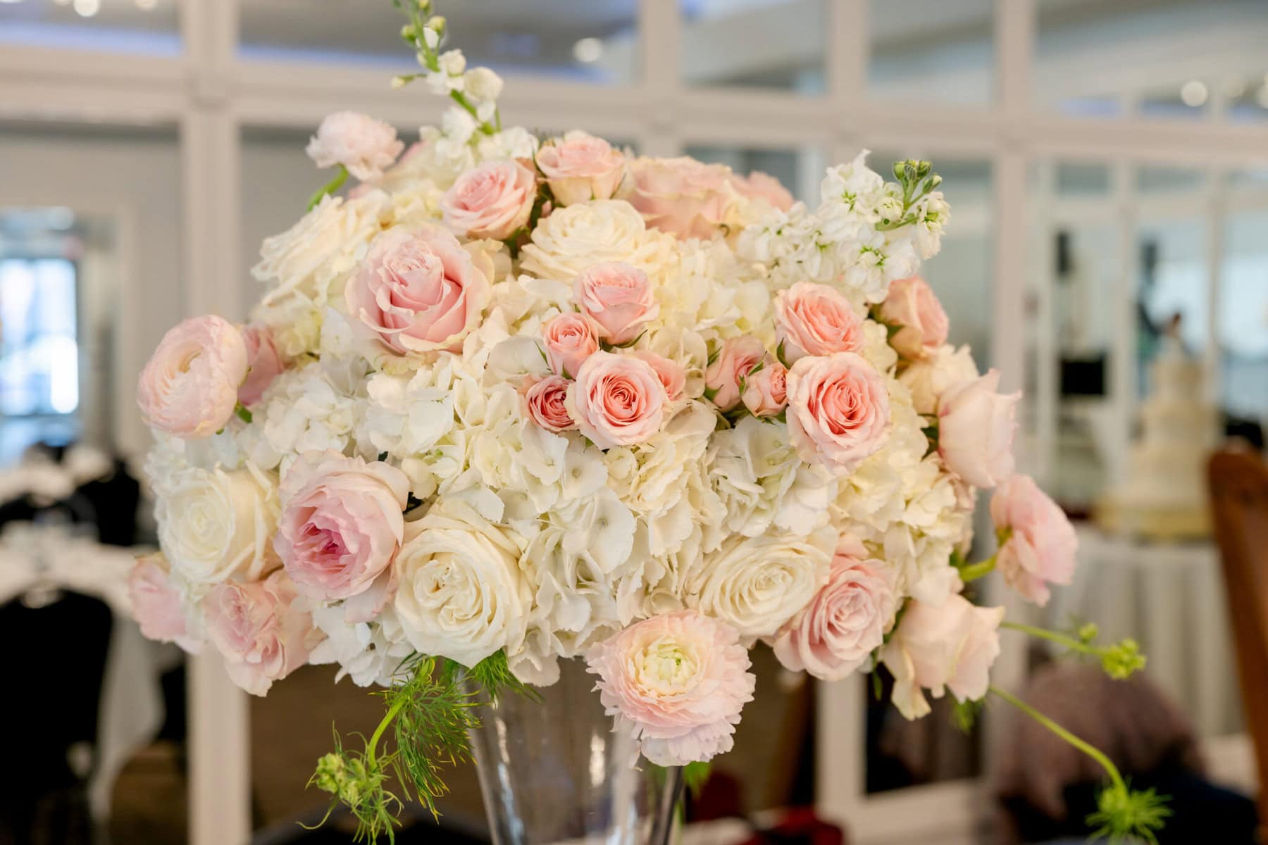 Wedding Reception at The Century House in Acushnet 3 A bouquet of white and pale pink roses and hydrangeas in a clear vase, perfect for a Wedding Reception at The Century House in Acushnet.