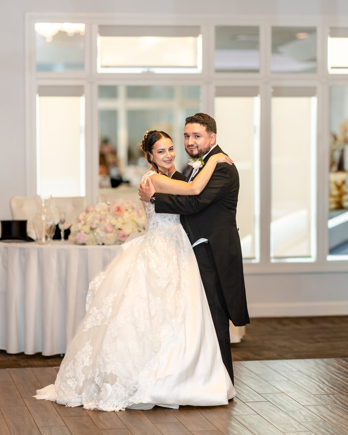 Wedding Reception at The Century House in Acushnet 15 A bride and groom in formal attire pose, smiling, at their elegant Acushnet wedding reception in The Century House.