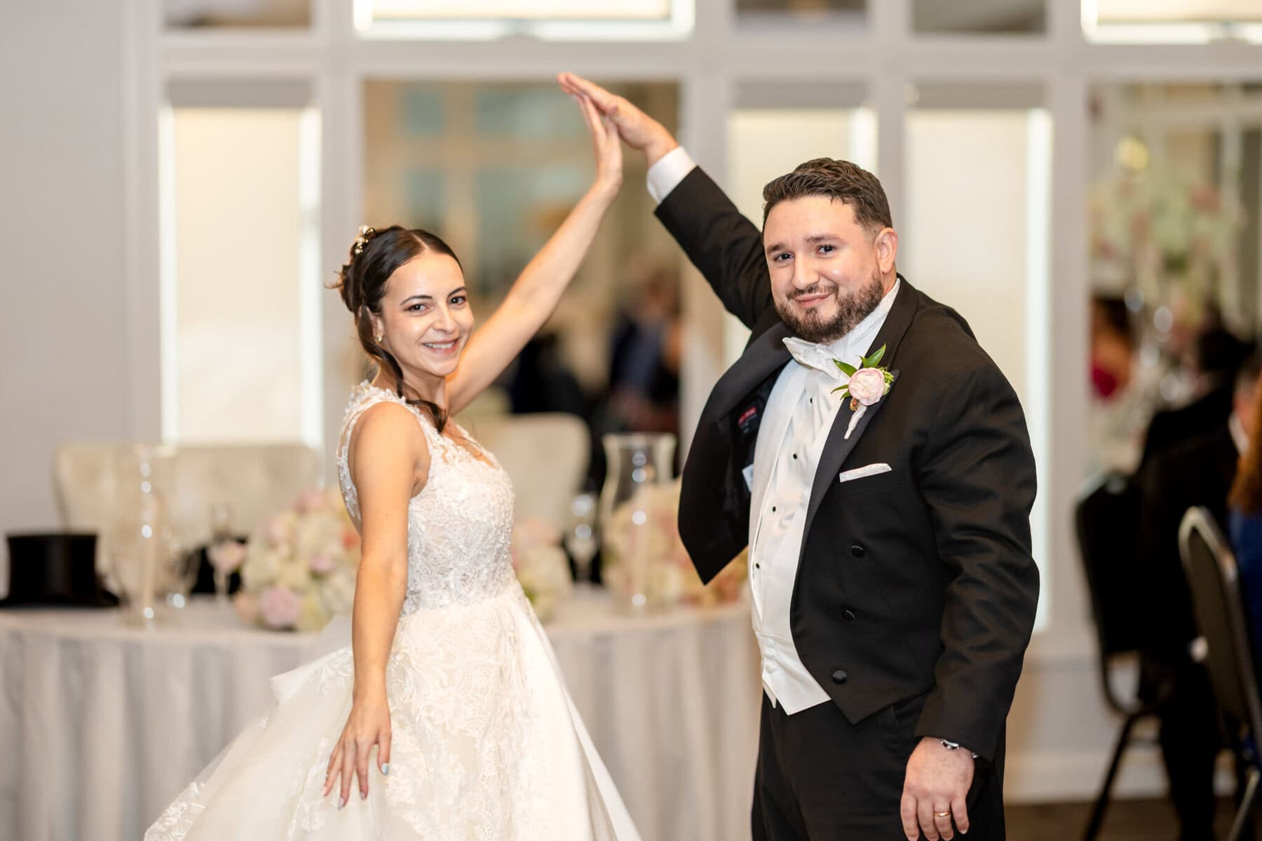 Wedding Reception at The Century House in Acushnet 18 A bride and groom dressed formally smile and hold hands on the dance floor at their The Century House wedding reception.