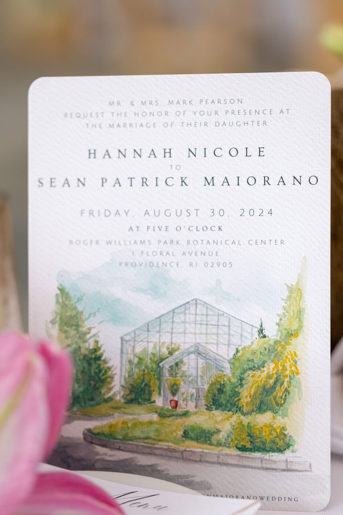Stunning Wedding at the Roger Williams Botanical Gardens 58 A wedding invitation card with a watercolor of Roger Williams Botanical Gardens' glass greenhouse, event details elegantly printed above.