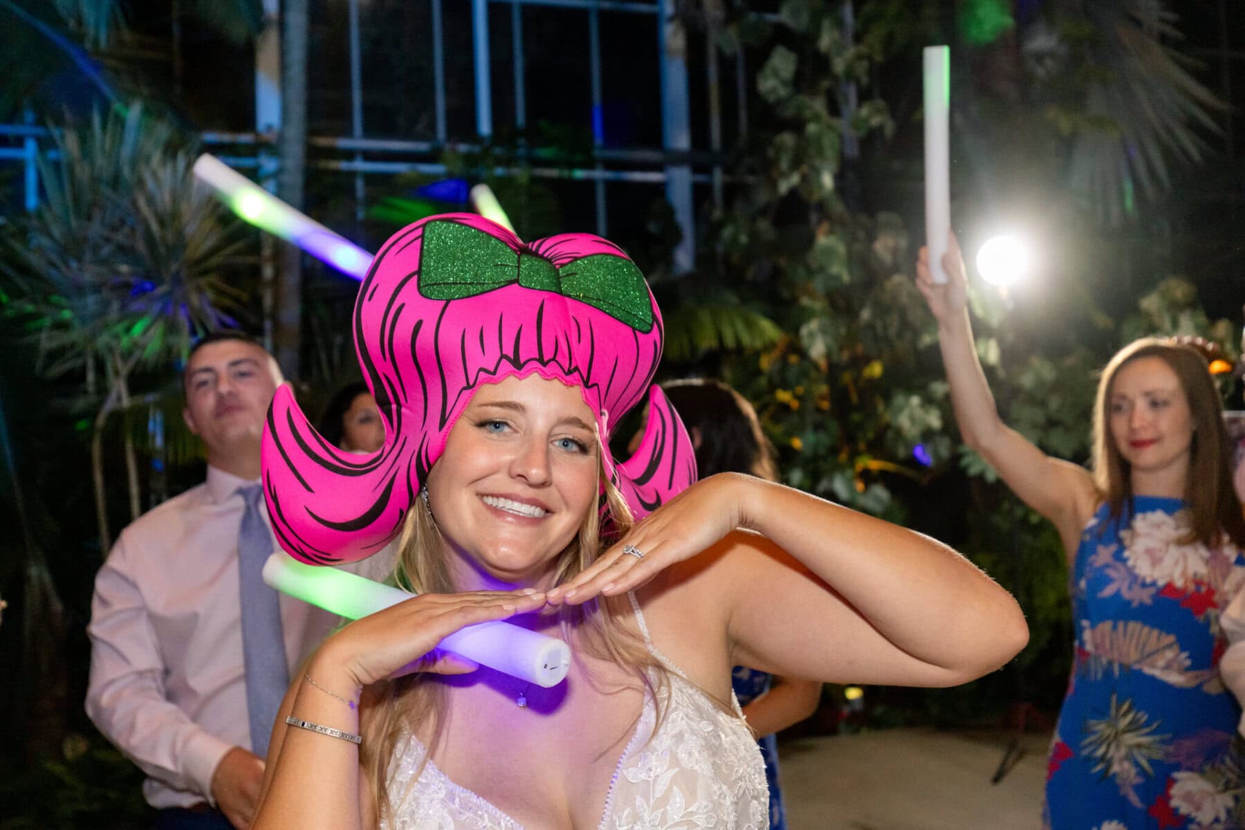 Stunning Wedding at the Roger Williams Botanical Gardens 88 A woman wearing a pink wig and holding a stick at Roger Williams Botanical Gardens.