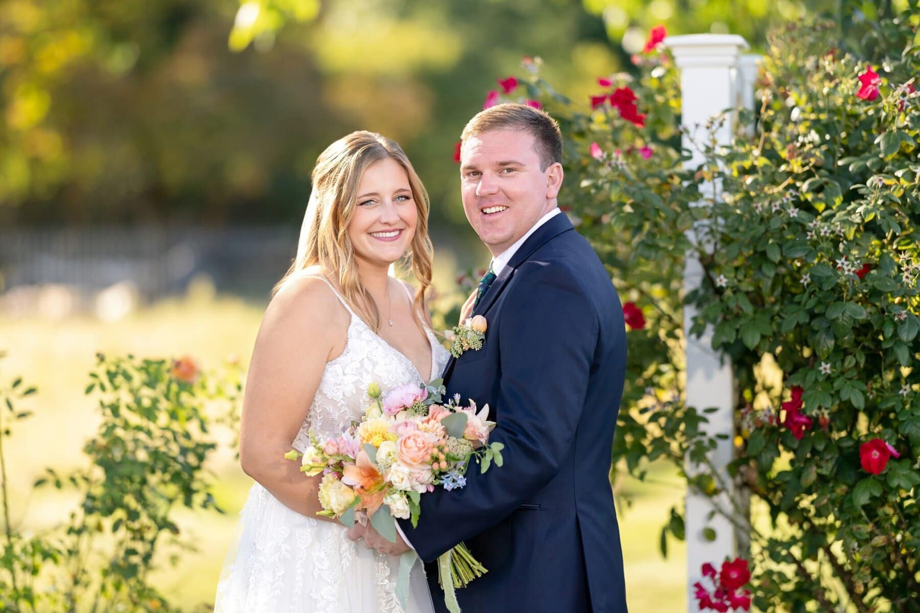 Stunning Wedding at the Roger Williams Botanical Gardens 98 A man and woman posing for a picture at Roger Williams Botanical Gardens, celebrating their wedding.