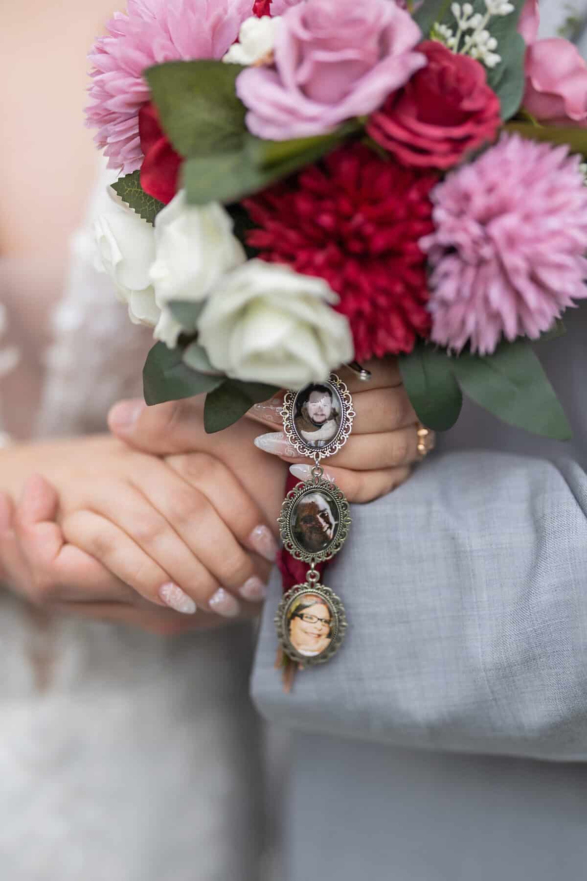 Wedding at the Springfield Elks lodge 40 A couple holds hands at their Springfield wedding, one in a white dress holding a bouquet adorned with three photo lockets featuring portraits of loved ones.