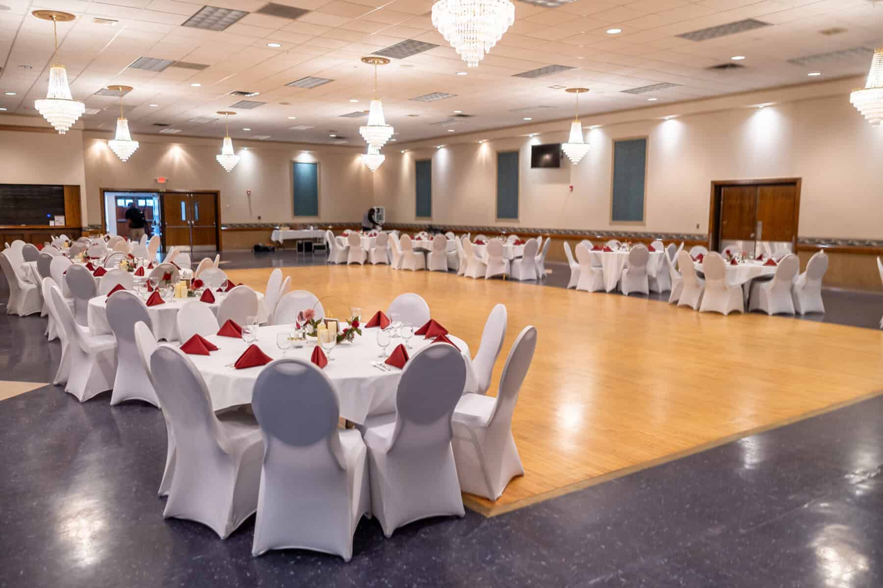 Wedding at the Springfield Elks lodge 53 A spacious banquet hall at the Springfield Elks Lodge features round tables with white cloths, red napkins, elegant chandeliers—perfect for a memorable wedding.