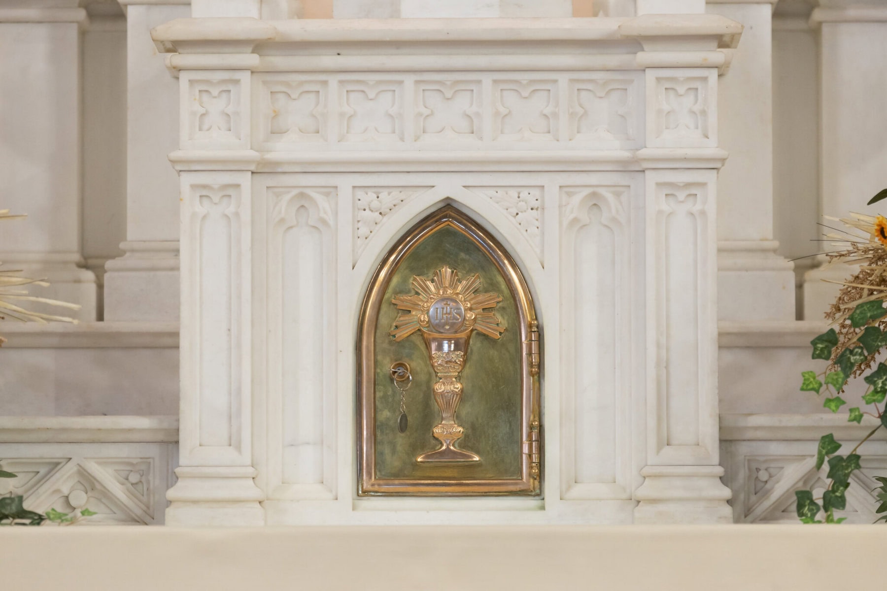 Wedding At St. Mary's Church in North Attleborough 12 A gold tabernacle door with a religious symbol graces the white marble altar at St. Mary’s Church in North Attleborough.
