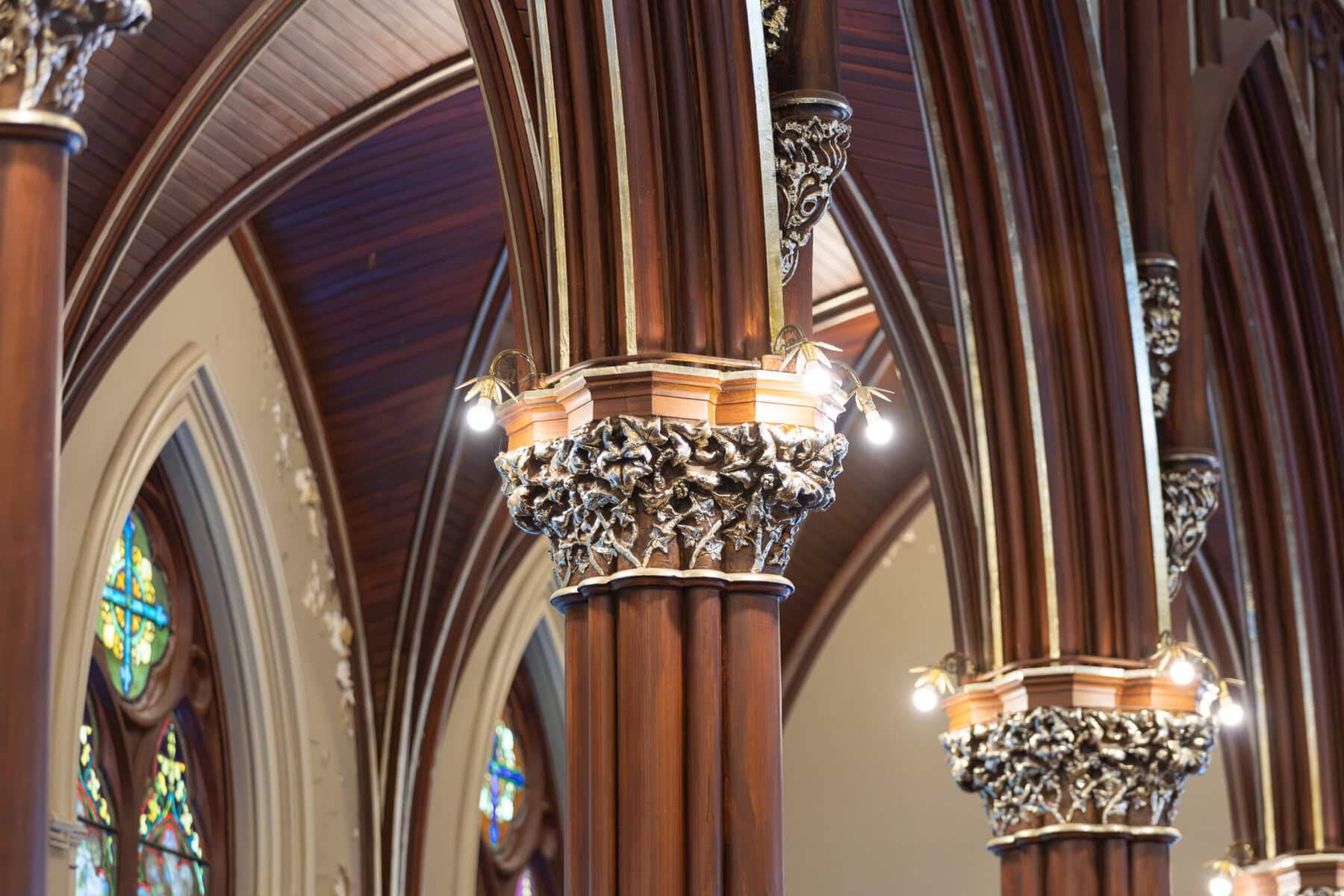 Wedding At St. Mary's Church in North Attleborough 6 Close-up of ornate columns and arches in St. Mary's Church, North Attleborough, with stained glass windows in the background.
