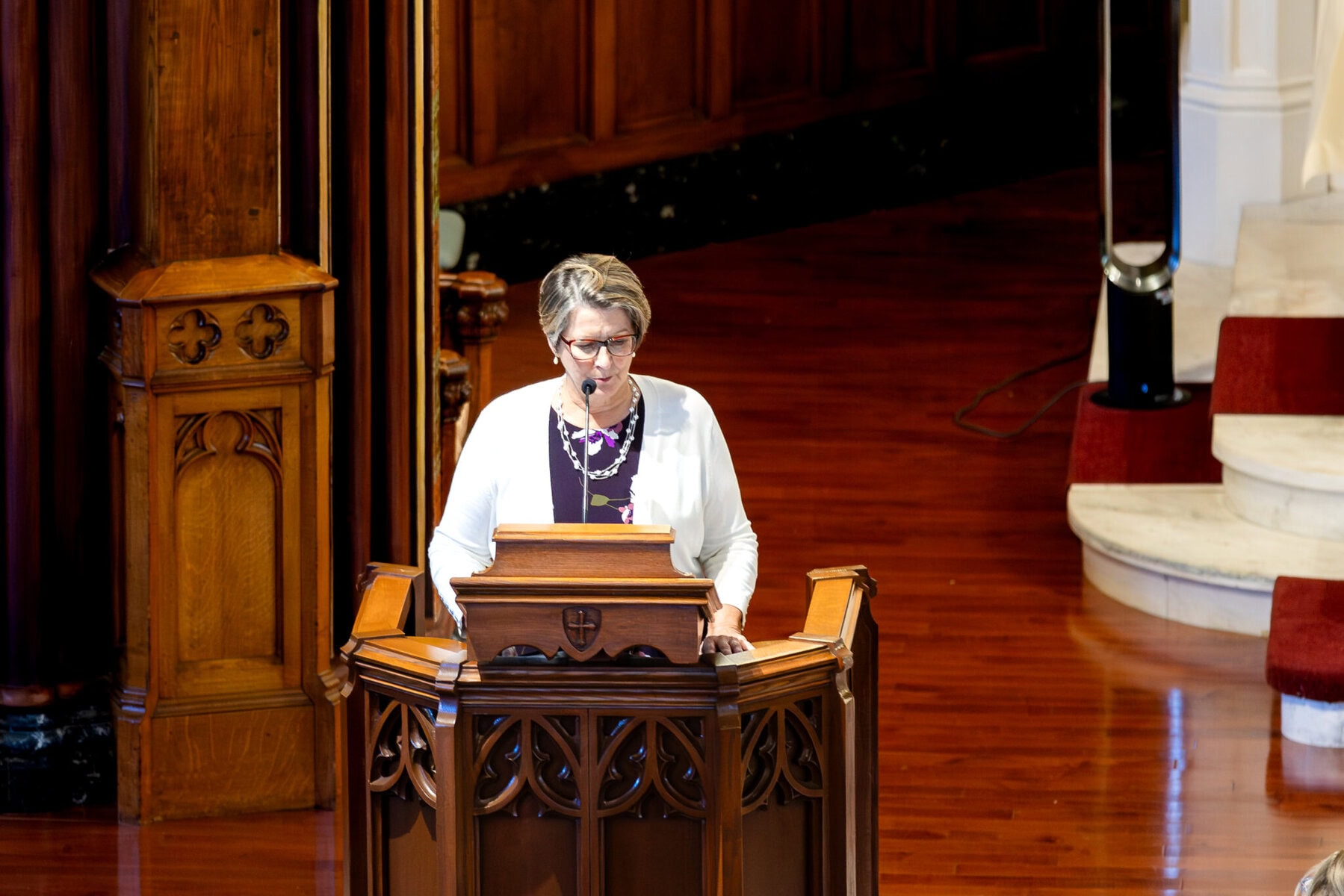 Wedding At St. Mary's Church in North Attleborough 30 A person stands at a wooden podium, speaking at a wedding in St. Mary's Church, North Attleborough, surrounded by polished wood décor.
