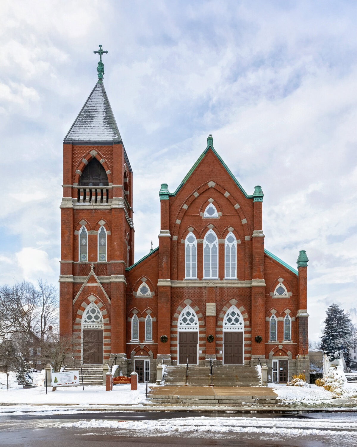 Wedding At St. Mary's Church in North Attleborough 47 A red brick church, named Transfiguration of the Lord, with a tall steeple and arched windows, awaits a winter Wedding on its snowy steps.