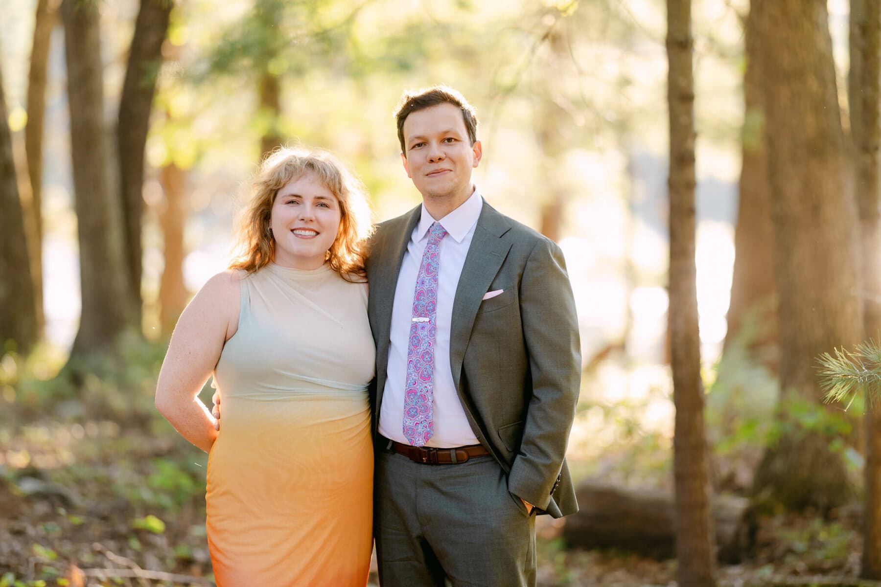 A Worcester Wedding at Cook Pond 81 Two people stand side by side in a forest at Cook Pond, one in a dress and one in a suit, posing for a Worcester Wedding photo.